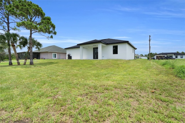 2505 40th, Lehigh Acres, FL 33976 - rear view of property featuring a yard and stucco siding