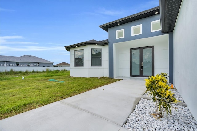 2505 40th, Lehigh Acres, FL 33976 - back of property featuring stucco siding, french doors, and a lawn