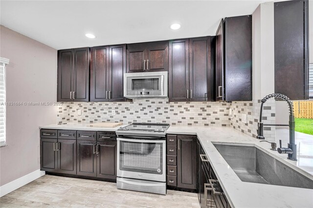 10527 NW 6th St, Pembroke Pines, FL 33026 - kitchen featuring appliances with stainless steel finishes, tasteful backsplash, light wood-style floors, recessed lighting, and dark brown cabinets