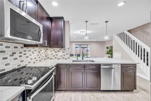 10527 NW 6th St, Pembroke Pines, FL 33026 - kitchen with stainless steel appliances, light wood-type flooring, a peninsula, decorative backsplash, and recessed lighting