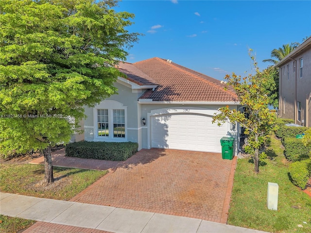 5342 SW 173rd Ave, Miramar, FL 33029 - mediterranean / spanish house featuring stucco siding, an attached garage, decorative driveway, and a tile roof