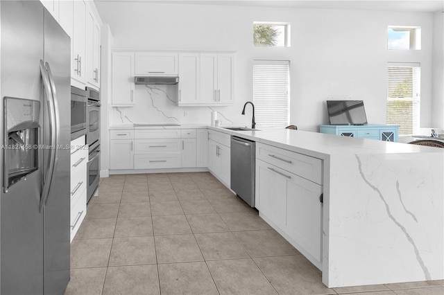 5342 SW 173rd Ave, Miramar, FL 33029 - kitchen with appliances with stainless steel finishes, a peninsula, white cabinetry, light stone counters, and light tile patterned flooring