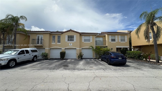 1145 Lake Shore Dr Unit 205, Lake Park, FL 33403 - multi unit property featuring stucco siding, a tiled roof, an attached garage, and driveway