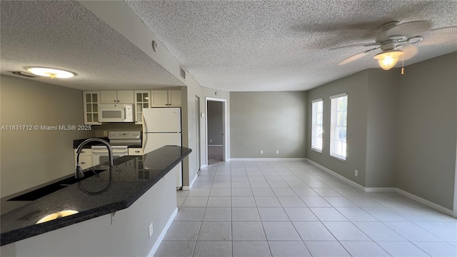 1145 Lake Shore Dr Unit 205, Lake Park, FL 33403 - kitchen with white appliances, glass insert cabinets, ceiling fan, a textured ceiling, and light tile patterned floors