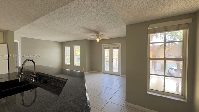 1145 Lake Shore Dr Unit 205, Lake Park, FL 33403 - kitchen featuring plenty of natural light, ceiling fan, light tile patterned floors, french doors, and a textured ceiling