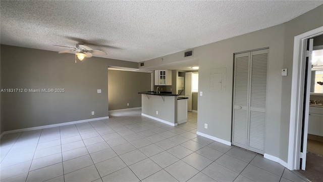 1145 Lake Shore Dr Unit 205, Lake Park, FL 33403 - unfurnished living room with ceiling fan, a textured ceiling, and light tile patterned flooring