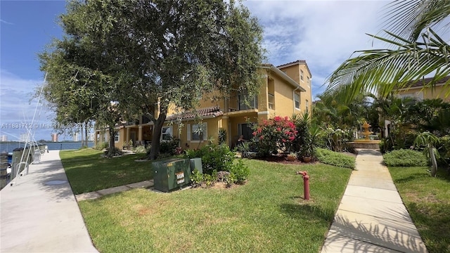 1145 Lake Shore Dr Unit 205, Lake Park, FL 33403 - view of front facade with a front yard, a tile roof, and stucco siding