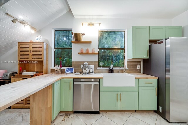 7900 SW Springhaven Ave, Indian Town, FL 34956 - kitchen featuring appliances with stainless steel finishes, green cabinets, lofted ceiling, and light countertops