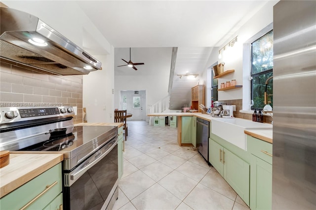 7900 SW Springhaven Ave, Indian Town, FL 34956 - kitchen featuring green cabinets, stainless steel appliances, exhaust hood, and backsplash