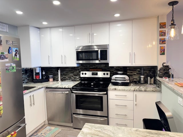 400 N Surf Rd Unit 804, Hollywood, FL 33019 - kitchen with stainless steel appliances, white cabinetry, tasteful backsplash, light stone counters, and recessed lighting