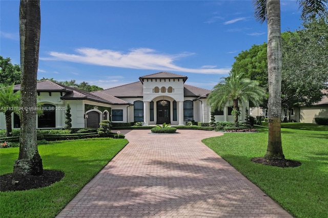11056 Blackhawk Blvd, Davie, FL 33328 - view of front facade with decorative driveway, a front lawn, stucco siding, and an attached garage