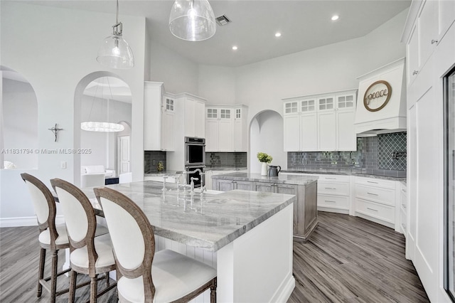 11056 Blackhawk Blvd, Davie, FL 33328 - kitchen featuring a center island with sink, stainless steel double oven, decorative backsplash, white cabinetry, and recessed lighting