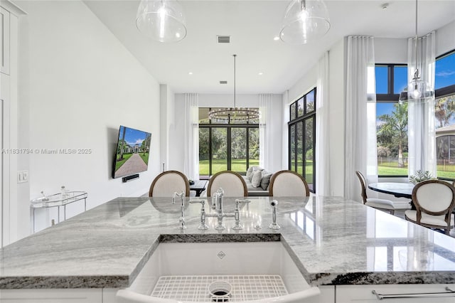 11056 Blackhawk Blvd, Davie, FL 33328 - kitchen featuring healthy amount of natural light, light stone counters, decorative light fixtures, recessed lighting, and a kitchen island with sink