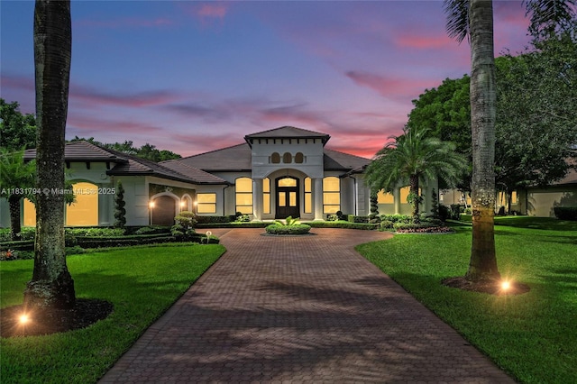 11056 Blackhawk Blvd, Davie, FL 33328 - mediterranean / spanish home with curved driveway, a yard, and stucco siding