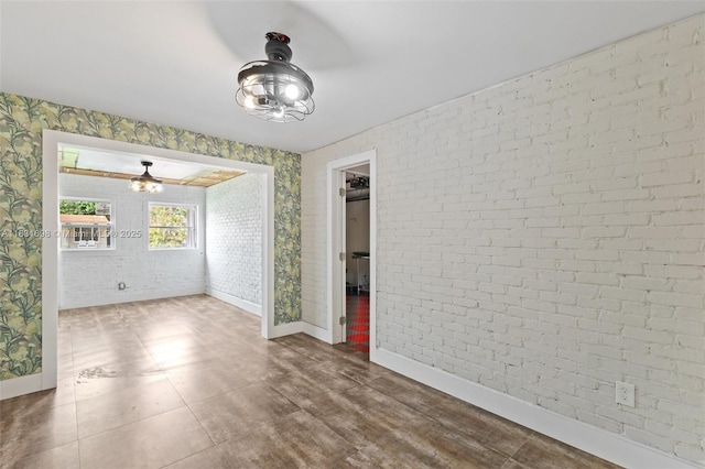 7201 Hayes St, Hollywood, FL 33024 - spare room with wallpapered walls, brick wall, and a ceiling fan