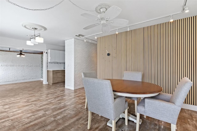 7201 Hayes St, Hollywood, FL 33024 - dining room featuring track lighting, brick wall, a ceiling fan, and wood finished floors