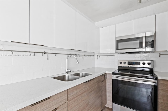 7201 Hayes St, Hollywood, FL 33024 - kitchen featuring stainless steel appliances, modern cabinets, tasteful backsplash, and white cabinetry