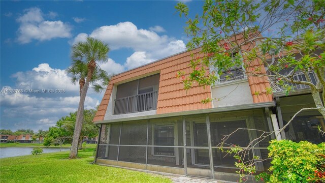11101 SW 15th Mnr, Davie, FL 33324 - view of home's exterior with a water view, a yard, and mansard roof
