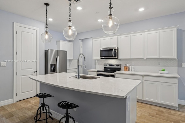 8367 NW 7th Pl Unit 0, Plantation, FL 33324 - kitchen featuring stainless steel appliances, light wood finished floors, a kitchen bar, white cabinetry, and recessed lighting