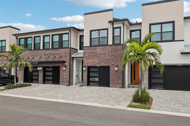 8367 NW 7th Pl Unit 0, Plantation, FL 33324 - view of front facade featuring an attached garage, stucco siding, driveway, and brick siding