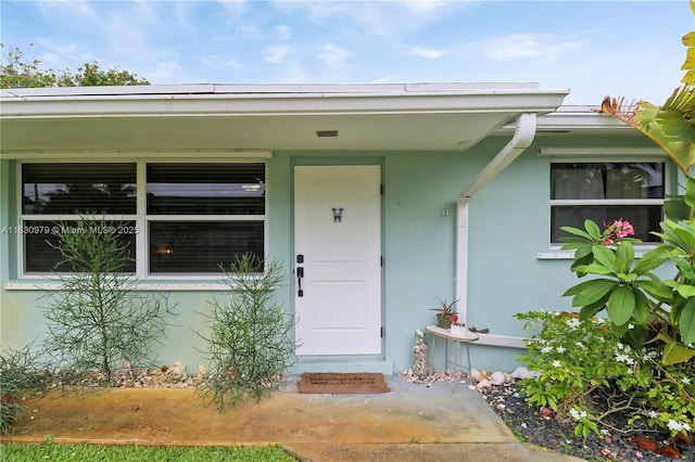 1884 Juno Rd, North Palm Beach, FL 33408 - doorway to property with stucco siding