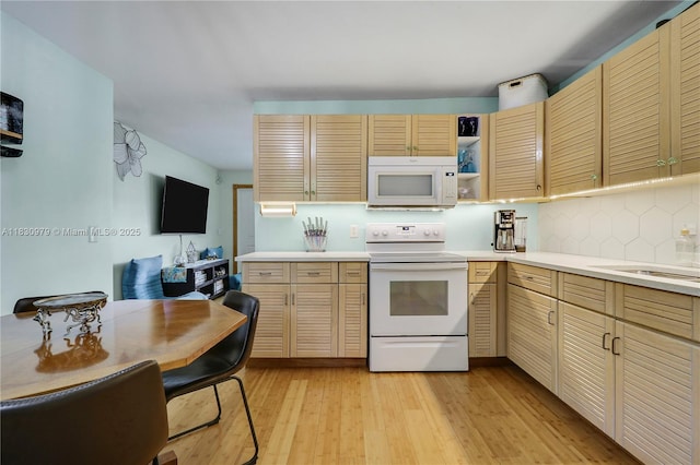 1884 Juno Rd, North Palm Beach, FL 33408 - kitchen with white appliances, light countertops, backsplash, and light wood-type flooring