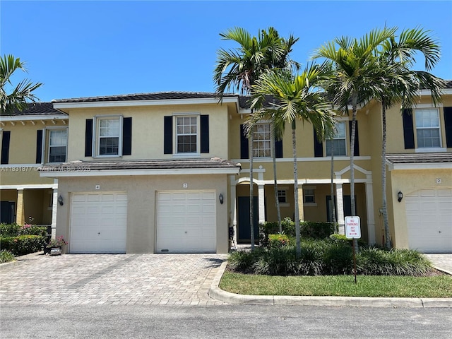 3 Largo Way, Boynton Beach, FL 33426 - townhome / multi-family property with stucco siding, a garage, driveway, and a tile roof
