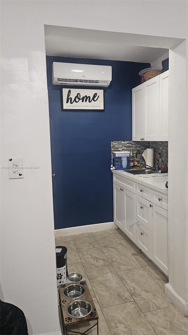 1014 W 68th St, Hialeah, FL 33014 - kitchen with an AC wall unit, white cabinetry, light countertops, and tasteful backsplash