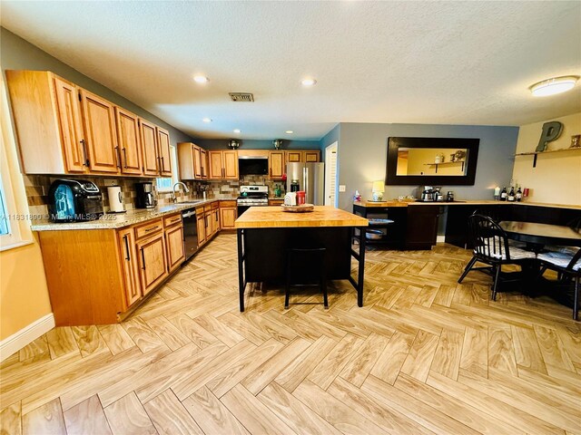 2980 SW 82nd Way, Davie, FL 33328 - kitchen with stainless steel appliances, decorative backsplash, brown cabinetry, recessed lighting, and a textured ceiling