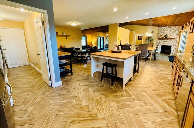 2980 SW 82nd Way, Davie, FL 33328 - kitchen with wooden counters, open floor plan, recessed lighting, white cabinets, and a kitchen bar