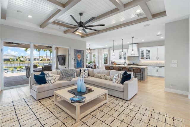 9369 Crestview Cir, Palm Beach Gardens, FL 33412 - living room with beamed ceiling, light wood finished floors, a ceiling fan, healthy amount of natural light, and recessed lighting