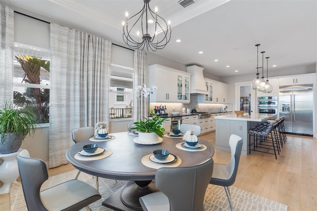 9369 Crestview Cir, Palm Beach Gardens, FL 33412 - dining area featuring light wood-style flooring, a chandelier, recessed lighting, and beverage cooler