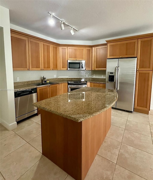 55 Merrick Way Unit 711, Coral Gables, FL 33134 - kitchen with stainless steel appliances, light tile patterned floors, a kitchen island, brown cabinetry, and dark stone countertops