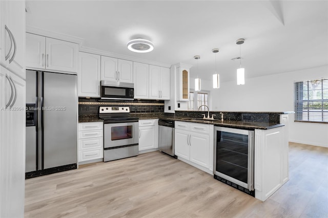 8031 NW 47th Ct, Lauderhill, FL 33351 - kitchen featuring appliances with stainless steel finishes, wine cooler, a peninsula, and white cabinets