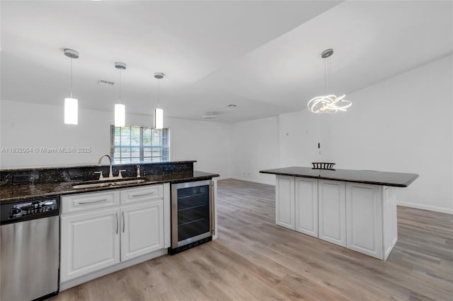 8031 NW 47th Ct, Lauderhill, FL 33351 - kitchen with stainless steel dishwasher, wine cooler, light wood-type flooring, white cabinets, and decorative light fixtures