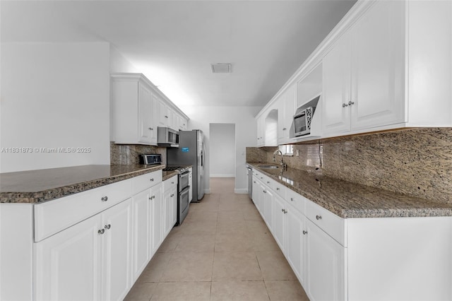 10600 SW 199th St, Cutler Bay, FL 33157 - kitchen with stainless steel appliances, decorative backsplash, white cabinets, and dark stone counters