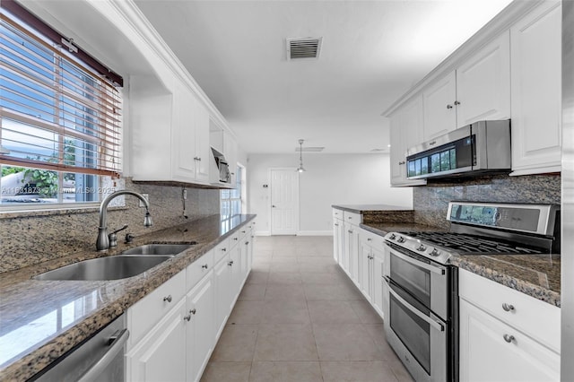 10600 SW 199th St, Cutler Bay, FL 33157 - kitchen with stainless steel appliances, backsplash, white cabinets, light tile patterned floors, and dark stone countertops