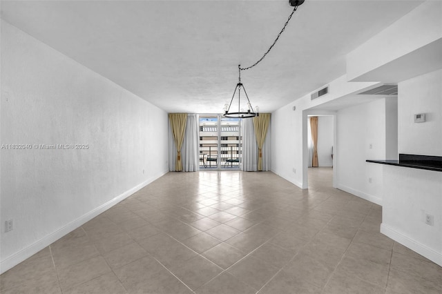 10350 W Bay Harbor Dr Unit 8F, Bay Harbor Islands, FL 33154 - empty room featuring a chandelier, tile patterned flooring, and a wall of windows