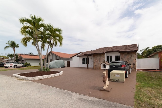 13250 SW 29th Ter, Miami, FL 33175 - view of front of home featuring decorative driveway, stone siding, a tile roof, and stucco siding