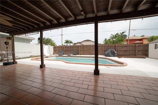 13250 SW 29th Ter, Miami, FL 33175 - view of swimming pool with a water slide, a patio area, a fenced backyard, and a storage unit
