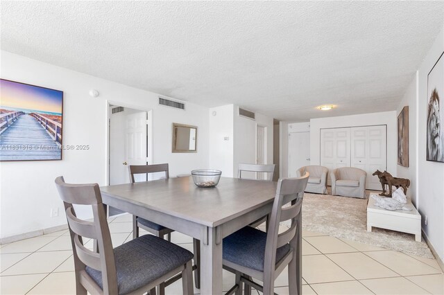 6770 Indian Creek Dr Unit 7A, Miami Beach, FL 33141 - dining area featuring light tile patterned flooring, a textured ceiling, and light carpet