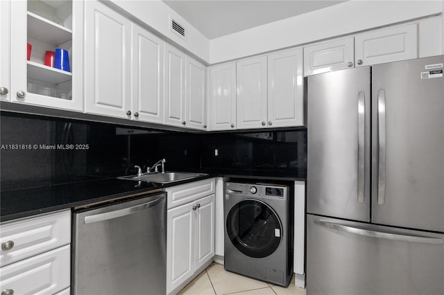 6770 Indian Creek Dr Unit 7A, Miami Beach, FL 33141 - kitchen with stainless steel appliances, washer / dryer, light tile patterned floors, and white cabinetry