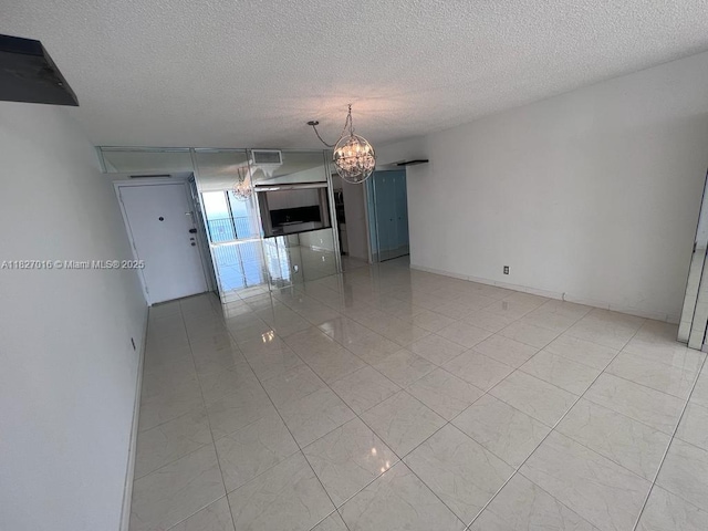 2101 S Ocean Dr Unit 2603, Hollywood, FL 33019 - spare room featuring a chandelier and a textured ceiling