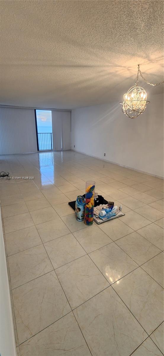 2101 S Ocean Dr Unit 2603, Hollywood, FL 33019 - tiled spare room featuring a textured ceiling and a chandelier