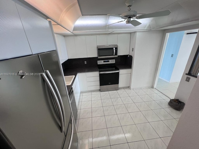 2101 S Ocean Dr Unit 2603, Hollywood, FL 33019 - kitchen with appliances with stainless steel finishes, dark countertops, white cabinets, ceiling fan, and light tile patterned flooring