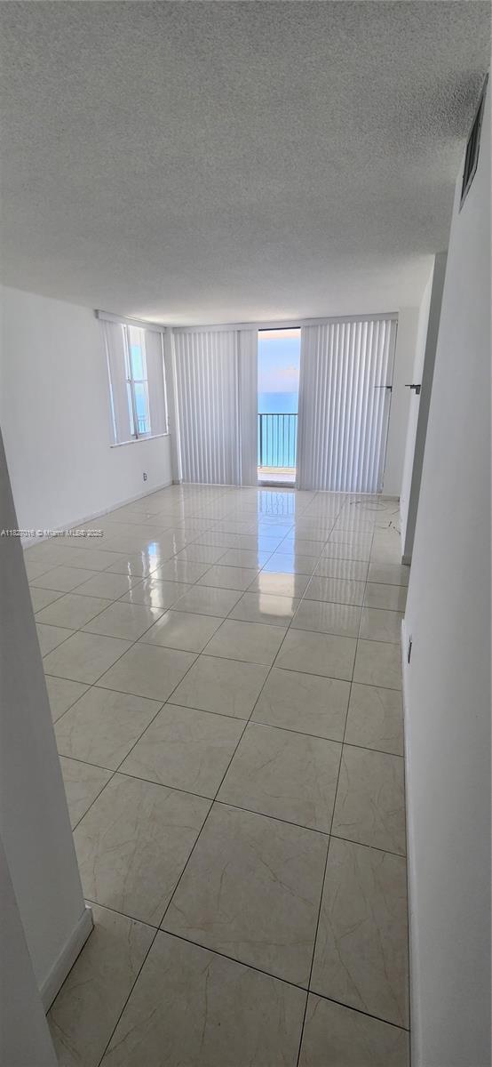 2101 S Ocean Dr Unit 2603, Hollywood, FL 33019 - empty room featuring healthy amount of natural light, a textured ceiling, and light tile patterned floors