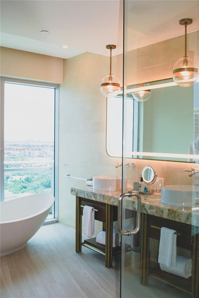 10295 Collins Ave Unit 1114, Bal Harbour, FL 33154 - bathroom featuring a soaking tub, wood finished floors, and vanity