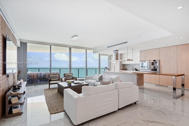 15701 Collins Ave Unit 2902, Sunny Isles Beach, FL 33160 - living room featuring light marble finish flooring, a wall of windows, and a water view