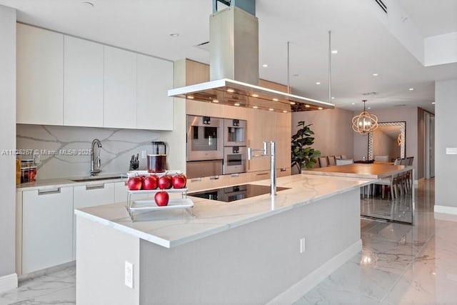 15701 Collins Ave Unit 2902, Sunny Isles Beach, FL 33160 - kitchen with island range hood, modern cabinets, light marble finish floors, white cabinetry, and hanging light fixtures