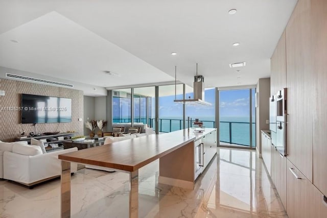 15701 Collins Ave Unit 2902, Sunny Isles Beach, FL 33160 - kitchen with modern cabinets, light marble finish flooring, extractor fan, expansive windows, and open floor plan